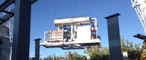 a crane lifting an industrial refrigeration chiller outdoors