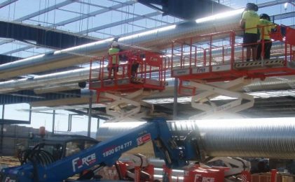 scissor lift with pipes on it at a construction site