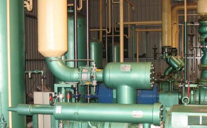 an industrial refrigeration strainer in a plant room with other equipment