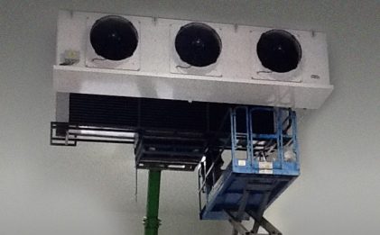 industrial refrigeration equipment being lifted on a knuckle boom