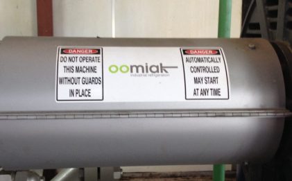 a cylindrical tank with two safety warning signs and an oomiak logo on it