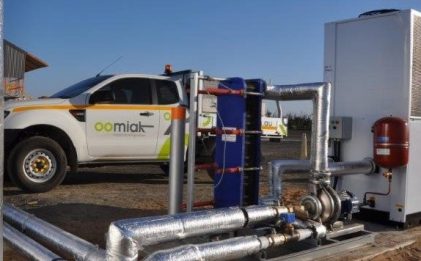 chilled water pump skid outside with a white car in the background with an oomiak logo on it