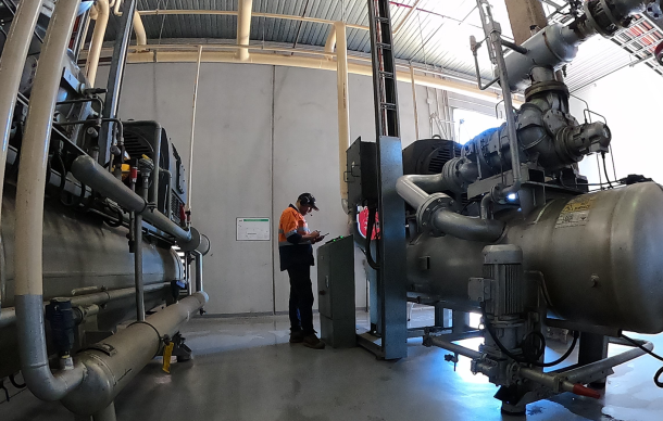 man wearing high vis performing maintenance works at an industrial refrigeration plant