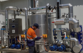 man wearing high vis workwear working on a piece of industrial refrigeration equipment outdoors